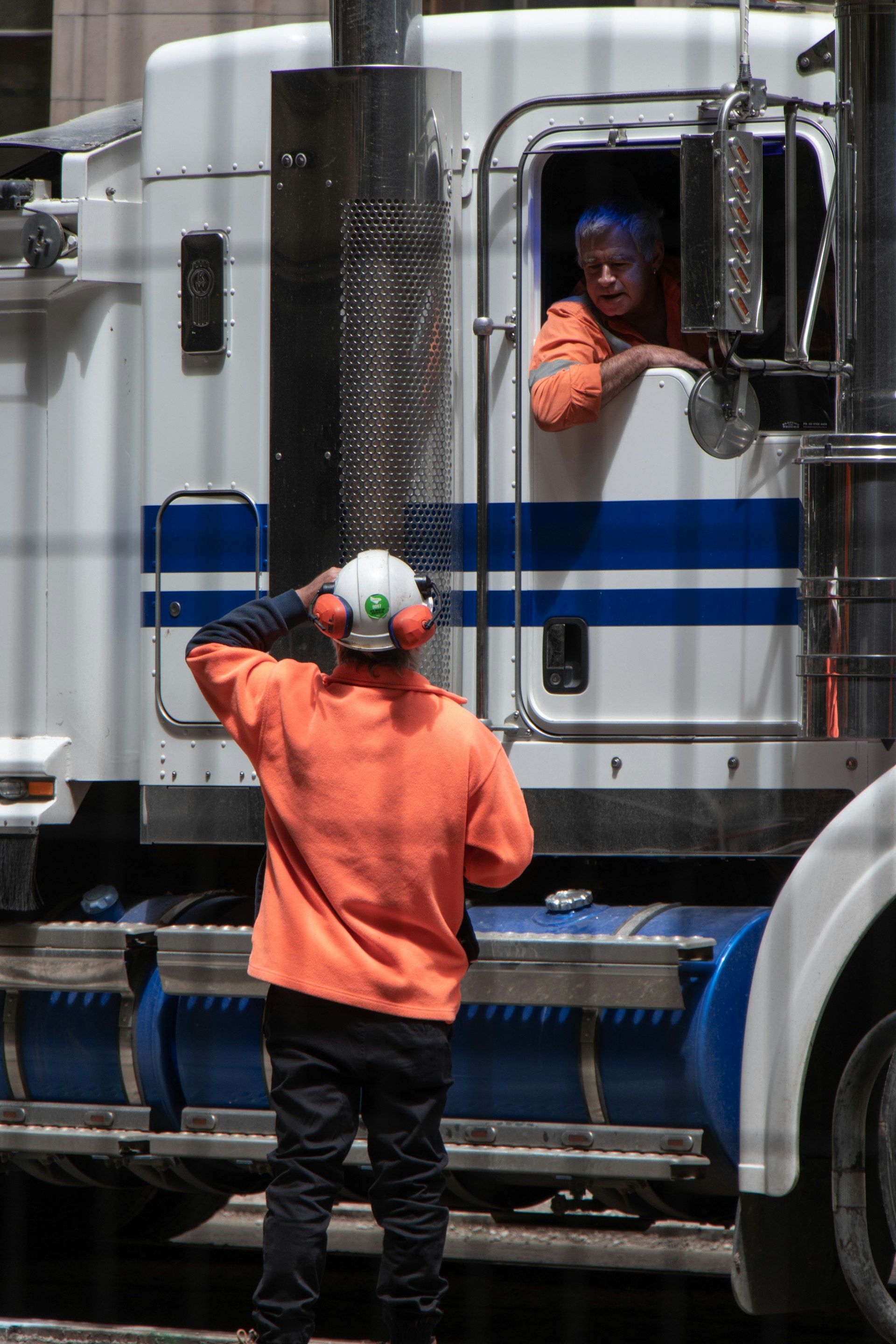 CDL truck driver standing in front of a Class-8 freight truck